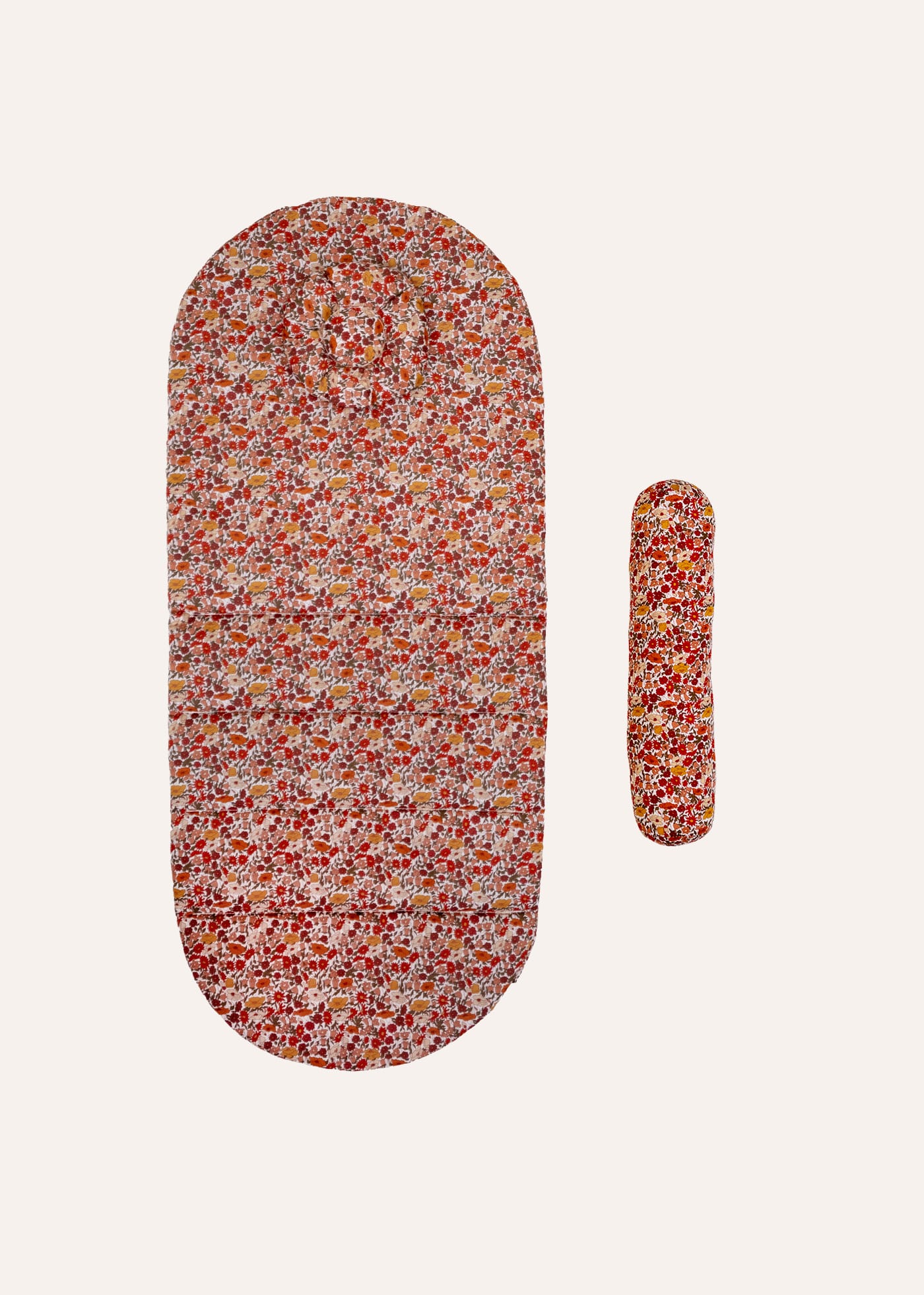 ErgoTopper Claire: quilted mat with red-orange floral pattern and matching positioning roll for the stroller