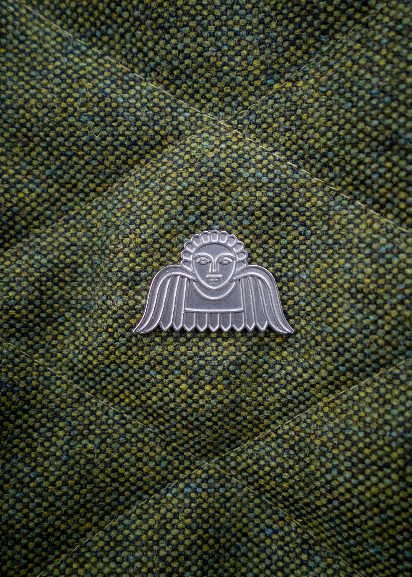 Silbernes ANGELCAB-Engelsemblem auf grünem Harris Tweed mit diagonaler Steppnaht